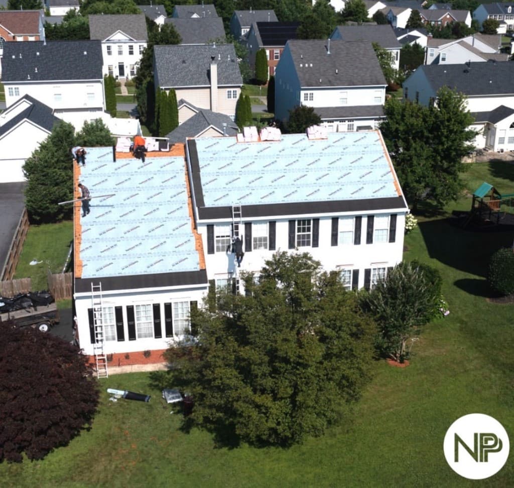 The same colonial home during roof replacement, with underlayment on the roof
